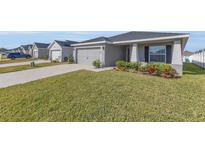 Gray house with gray driveway and landscaped lawn at 1065 Silas St, Haines City, FL 33844