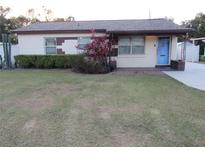 Ranch-style home with a well-maintained lawn and a blue front door at 1125 S Woodlawn Ave, Bartow, FL 33830