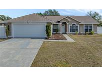 One-story house with attached garage and landscaped yard at 140 Bentley Oaks Blvd, Davenport, FL 33896