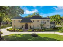 Brick home with a large front yard, circular driveway and mature landscaping at 1419 Hollingsworth Oaks Dr, Lakeland, FL 33803