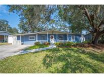 Charming ranch home with blue exterior, landscaping, and a walkway at 1632 Tangerine St, Lakeland, FL 33803