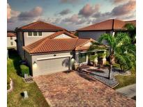 Two-story house with tile roof, paver driveway, and landscaping at 1958 Altavista Cir, Lakeland, FL 33810