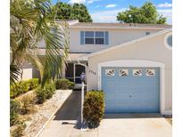 Two-story townhome with light-blue garage door and landscaping at 2348 Isle Royale Se Ct, Winter Haven, FL 33880