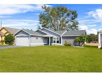 Gray house with white garage door and green lawn at 6235 Egret Dr, Lakeland, FL 33809