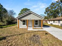 Newly constructed home with gray siding, wood post porch and a paved driveway at 631 S Westgate Ave, Lakeland, FL 33815