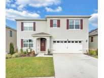 Two-story house featuring a two-car garage and well-manicured lawn at 637 Griffon Ave, Lake Alfred, FL 33850