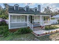 Charming two-story home featuring a cozy front porch with white railings and well-manicured landscaping at 1841 Casco St, Lakeland, FL 33801