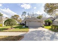 Charming single-story home featuring a well-manicured lawn and two-car garage at 1961 Rocky Pointe Dr, Lakeland, FL 33813