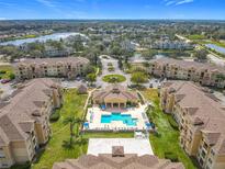 Stunning aerial view of community featuring a pool, manicured grounds, and access to a beautiful lake at 205 Terrace Ridge Cir # 205, Davenport, FL 33896