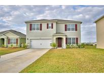 Charming two-story home featuring a well-manicured lawn and attached two-car garage at 2816 Ivy Lake Ct, Lakeland, FL 33811