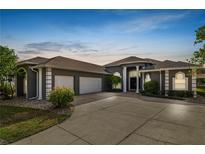 Stunning home featuring meticulously landscaped grounds, porte cochere, and a spacious three-car garage at 2859 Medinah Cir, Lakeland, FL 33803