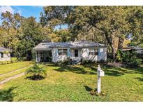 Charming single story home with a well maintained lawn, mature trees, and blue shutters at 424 S Elm Rd, Lakeland, FL 33801