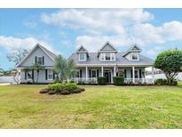 Charming single-Gathering home featuring a welcoming front porch, lush lawn, and manicured landscaping for great curb appeal at 5155 Lake Deeson Woods Ct, Lakeland, FL 33805