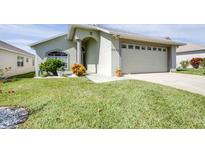 Inviting single-story home featuring well-manicured lawn, two-car garage, and meticulously maintained landscaping at 6962 Starmount Dr, Lakeland, FL 33810