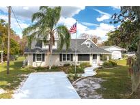 Charming home with a well-manicured lawn, a palm tree, and an American flag at 1290 S Mcadoo Ave, Bartow, FL 33830