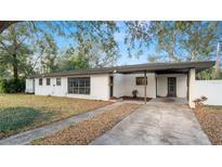 Charming white brick home featuring a covered carport and well-maintained landscaping at 1632 Sims Pl, Lakeland, FL 33803