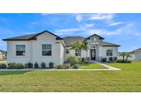 Beautiful one-story home with a well-manicured lawn, featuring a stone accent entryway, and decorative landscaping at 2985 Pickards Pass, Lakeland, FL 33813