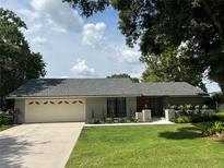 Lovely home with a manicured lawn, beautiful landscaping, and an attached two-car garage at 362 Pasco Ct, Winter Haven, FL 33884