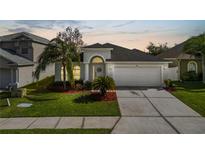 Charming single-story home featuring a well-manicured lawn, mature trees, and an attached two-car garage at 3961 Hampton Hills W Dr, Lakeland, FL 33810