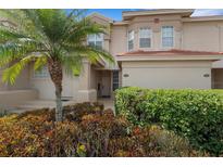 Two story tan home featuring a palm tree and manicured bushes at 417 Enclave Pl # 2, Lakeland, FL 33803