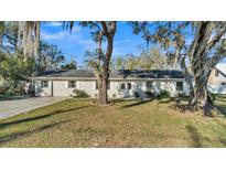 Charming single-story home with mature trees and a well-manicured front lawn at 4601 Sw Reynosa Sw Dr, Winter Haven, FL 33880