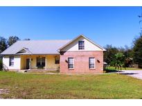 Charming house with a metal roof, brick section, and a cozy front porch at 5626 Sawyer Rd, Lakeland, FL 33810