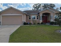 Charming single-story home with a well-manicured lawn and stone-accented entryway at 5752 Woodruff Way, Lakeland, FL 33812