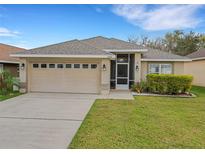 Charming single-story home with a well-maintained lawn, attached garage, and a cozy screened front entrance at 6838 Shimmering Dr, Lakeland, FL 33813