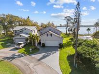 Inviting two-story home features an attached garage, a lush lawn, and beautiful lake views at 720 Lake Jessie Dr, Winter Haven, FL 33881