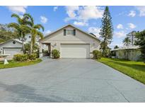 Charming home featuring a two-car garage, well-manicured landscaping, and a long driveway at 720 Lake Jessie Dr, Winter Haven, FL 33881