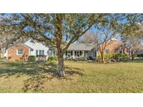 Charming one-story home with a manicured lawn, mature landscaping, and inviting front porch at 860 Lila St, Bartow, FL 33830