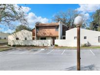 Inviting exterior view of condo featuring two-story design, stucco walls, and convenient parking at 1880 N Crystal Lake Dr # 4, Lakeland, FL 33801