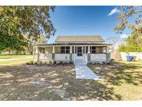 Charming single-story home featuring a cozy front porch with white railings and manicured landscaping at 22 S Cherokee Ave, Fort Meade, FL 33841