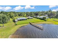 Waterfront property with a long pier and beautiful lake views from an aerial perspective on a bright and sunny day at 5418 Cooper Ln, Fort Meade, FL 33841