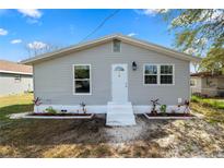 Charming single Gathering home with a light gray exterior, manicured garden bed, and new windows at 118 W Northside Dr, Lake Wales, FL 33853