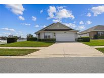 Charming single-story home featuring a manicured lawn, white garage door, and trimmed hedges at 1706 Tressel Ct, Winter Haven, FL 33881