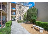 Charming condo building featuring well-maintained landscaping, a walkway, and inviting benches at 2025 Sylvester Rd # N106, Lakeland, FL 33803