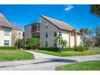 Well-maintained building exterior featuring a modern architectural style, balconies, and lush landscaping with palm trees at 2025 Sylvester Rd # N106, Lakeland, FL 33803
