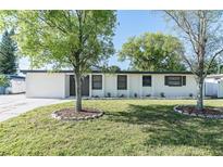 Charming single-story home with a well-maintained lawn and shade trees in a suburban neighborhood at 2521 Coral Way, Lakeland, FL 33801