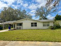 Charming single-story home featuring a well-maintained lawn, covered front porch, and mature trees at 3023 Maplewood Ave, Lakeland, FL 33803