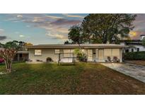 Charming single-story home with well-manicured lawn and inviting front porch swing at 3207 S Polk Ave, Lakeland, FL 33803