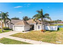 Charming single Gathering home with a two car garage, mature palm trees, and well-maintained landscaping at 3882 Rollingsford Cir, Lakeland, FL 33810