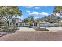 Charming two-story home featuring black shutters, manicured landscaping and a brick paved street at 511 Mcrorie St, Lakeland, FL 33803