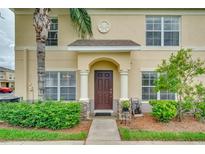 Inviting home entrance with a well-manicured garden, lush green shrubbery and a beautiful brown front door at 5377 Quarry Rock Rd, Lakeland, FL 33809