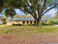 Charming single-story home featuring an arched porch and a mature tree in the front yard at 5422 Oakway Dr, Lakeland, FL 33805