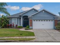 Charming single-story home features a well-manicured lawn, brick accents, and a two-car garage at 7104 Lake Eaglebrooke Way, Lakeland, FL 33813