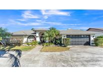 Charming single-story home featuring a manicured lawn, mature landscaping, and attached two-car garage at 7321 Gunstock Dr, Lakeland, FL 33809