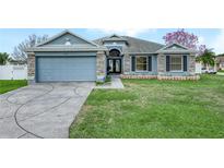 Charming single-story home with blue exterior, stone accents, well-manicured lawn and inviting curb appeal at 8350 Split Creek Cir, Lakeland, FL 33809