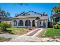 Charming home featuring arched windows, a brick driveway, and a welcoming front yard at 949 Success Ave, Lakeland, FL 33801