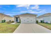 Charming single-story home featuring a two-car garage, lush lawn and well-maintained landscaping at 965 Eagle Rock Ter, Winter Haven, FL 33880